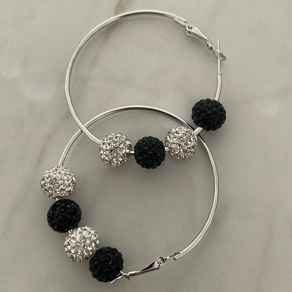 Silvertone hoop earrings with clear rhinestone and black jet like balls.